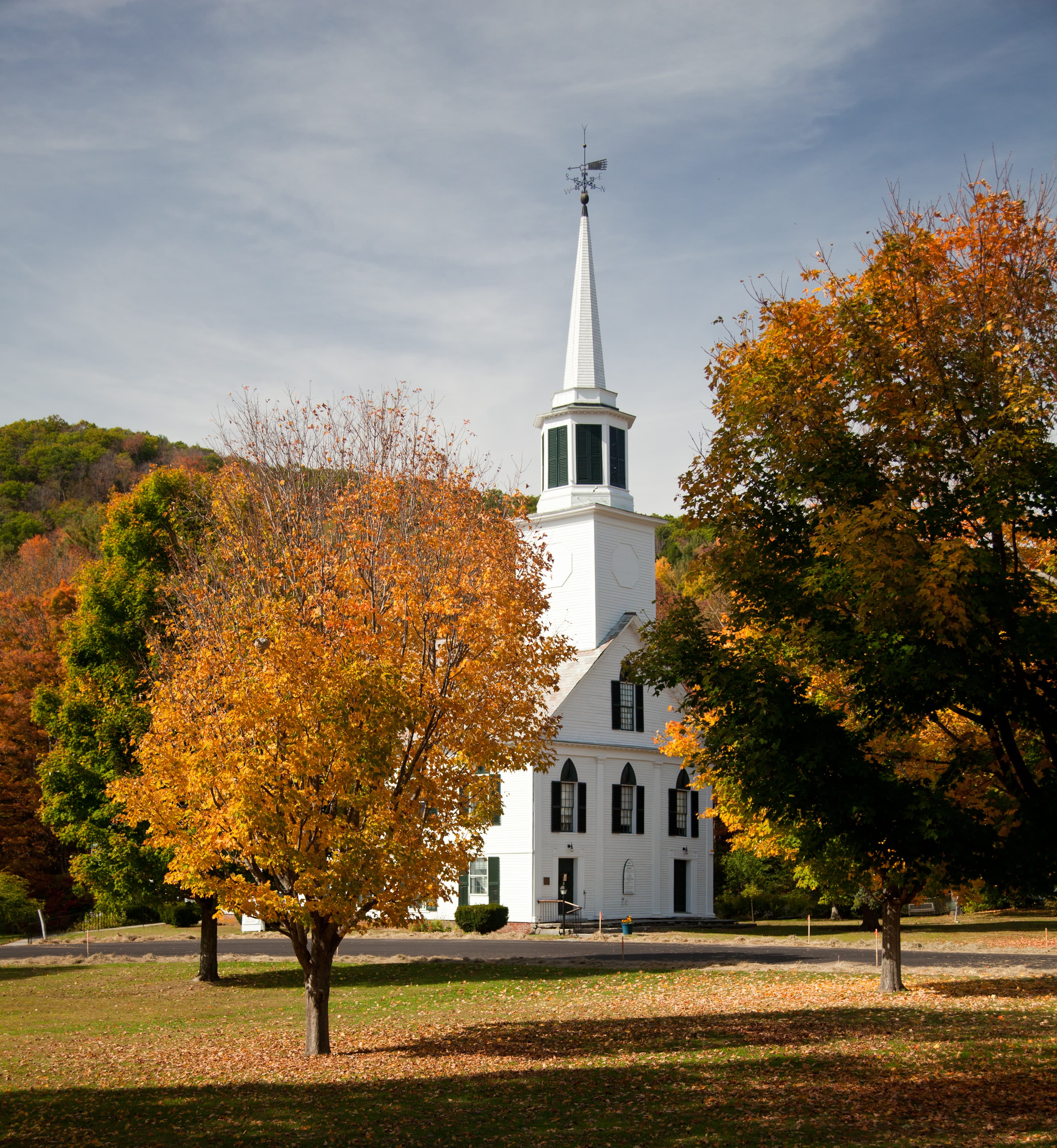 White church surrounded by autumn trees